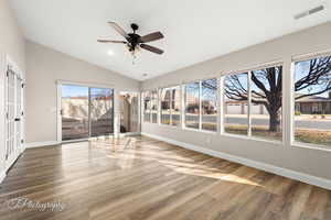 Unfurnished sunroom featuring vaulted ceiling, wood finished floors, and recessed lighting