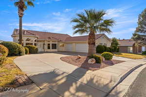 Mediterranean / spanish home featuring concrete driveway, a tiled roof, an attached garage, and stucco siding