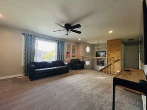 Carpeted living area with a chandelier, recessed lighting, and a ceiling fan