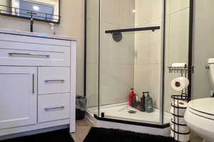 Full bath with toilet and a shower stall