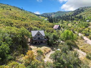 Front view from above of property featuring a heavily wooded area and mountains