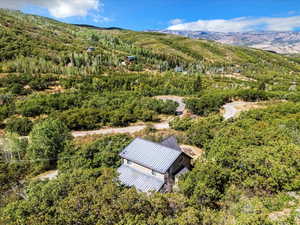 Rear view of property with a forest and mountains