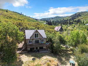 View of subject property with a forest and a mountainous background