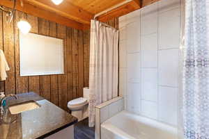 Full bathroom with vanity, shower / tub combo, and dark wood finished floors
