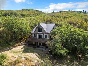 Aerial view of property and surrounding area with a forest