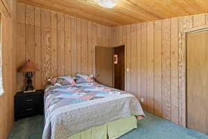 Bedroom #2 featuring wooden walls and a wood ceiling
