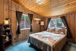 Bedroom #1 featuring wood walls, carpet floors, and a wood ceiling