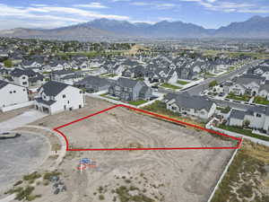 Aerial view of residential area featuring a mountainous background and property boundaries highlighted