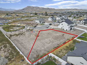 Aerial perspective of suburban area with a mountainous background and property parcel outlined