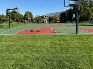View of basketball court featuring a mountain view, a lawn, and community basketball court