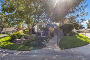 View of property hidden behind natural elements featuring a front lawn
