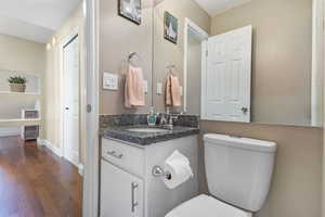 Half bath featuring dark wood-style flooring and vanity