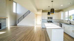 Kitchen with white cabinetry, a center island, stainless steel appliances, light wood-style flooring, and recessed lighting