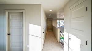 Hall featuring an upstairs landing, recessed lighting, and light colored carpet