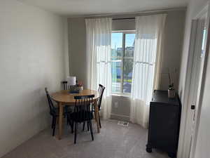 Dining area with light colored carpet and baseboards