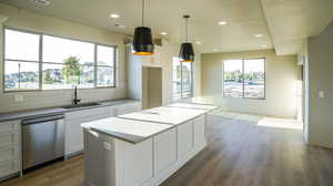 Kitchen with dishwasher, recessed lighting, white cabinetry, decorative backsplash, and a center island