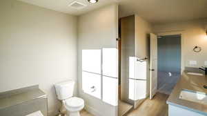 Full bath with light wood-style flooring and double vanity