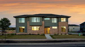 Modern home featuring a front yard and brick siding