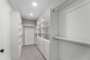 Large walk in closet featuring custom designed cabinets with many drawers and adjustable shelving