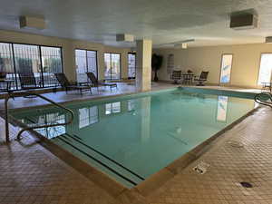 View of indoor community pool with hot tub