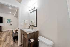Half bathroom with vanity, dark wood-style floors, and recessed lighting