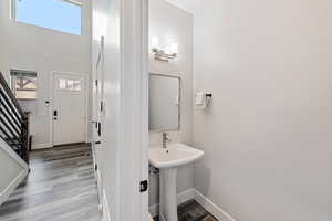 Bathroom featuring dark wood-type flooring and a high ceiling