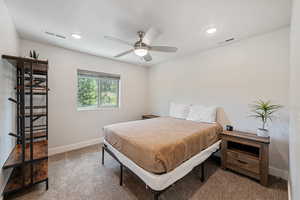 Carpeted bedroom featuring ceiling fan and recessed lighting