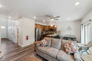 Living area with dark wood-style floors, recessed lighting, and a ceiling fan