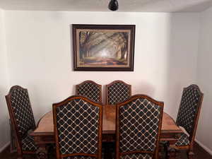Dining space featuring a textured ceiling and baseboards