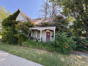 View of front of home featuring covered porch, stucco siding, and a front lawn