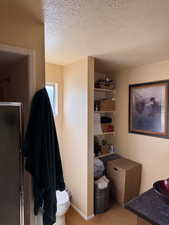 Full bath featuring a textured ceiling and a stall shower