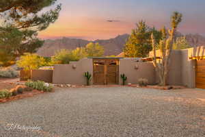 Yard at dusk with a gate, a fenced front yard, and a mountain view