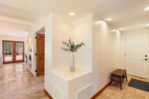 Corridor with stone tile floors and recessed lighting