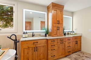 Bathroom featuring double vanity and a soaking tub