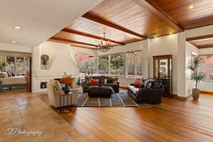 Living area featuring recessed lighting, a chandelier, light wood-style flooring, and a wood ceiling with exposed beams