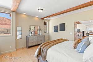 Bedroom with beam ceiling, multiple windows, recessed lighting, light wood-style flooring, and a mountain view