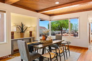 Dining room with light wood finished floors and a wooden ceiling with exposed beams