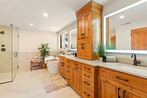 Bathroom with a stall shower, a freestanding tub, double vanity, a wainscoted wall, and recessed lighting