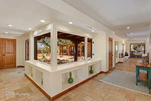 Corridor with recessed lighting, stone tile floors, and healthy amount of natural light