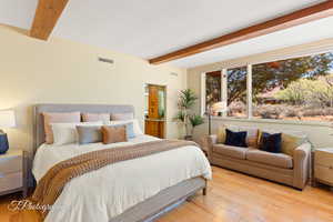 Bedroom with beamed ceiling and wood-type flooring