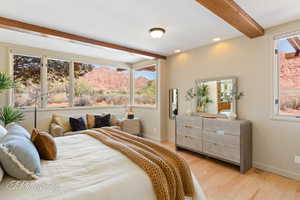 Bedroom featuring beam ceiling, light wood-style flooring, a mountain view, multiple windows, and recessed lighting