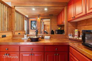Kitchen featuring wooden walls and wood ceiling