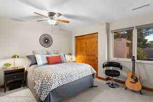 Carpeted bedroom with a closet and ceiling fan