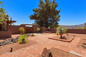 Fenced backyard featuring a patio area and a mountain view