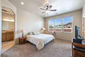 Bedroom featuring light colored carpet, a ceiling fan, recessed lighting, connected bathroom, and light tile patterned flooring
