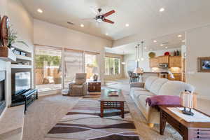 Living room with recessed lighting, a glass covered fireplace, a ceiling fan, and light tile patterned floors