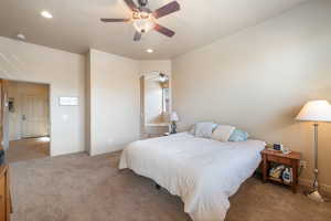 Carpeted bedroom featuring a ceiling fan and recessed lighting