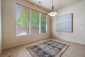 Unfurnished dining area featuring light tile patterned floors and baseboards