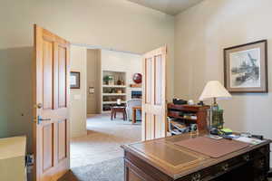 Home office with light tile patterned floors and a fireplace