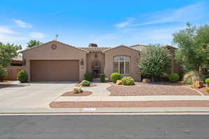 Mediterranean / spanish-style house featuring concrete driveway, stucco siding, a tiled roof, and an attached garage